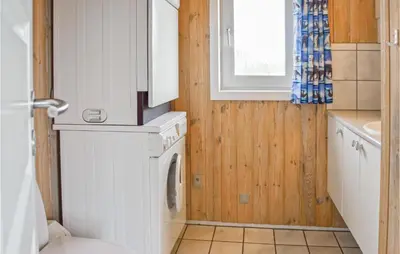 a small bathroom with a washer and dryer at Four-Bedroom Holiday Home In Thisted in Thisted