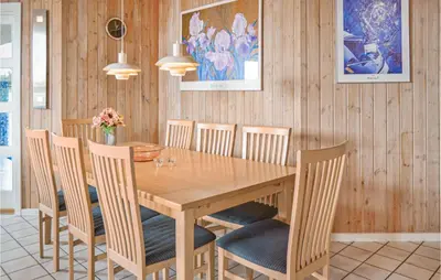 a dining room with a wooden table and chairs at Four-Bedroom Holiday Home In Thisted in Thisted