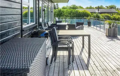 a deck with chairs and a table on a house at Three-Bedroom Holiday Home In Spottrup in Spottrup