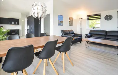 a living room with a dining room table and chairs at Three-Bedroom Holiday Home In Spottrup in Spottrup