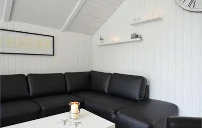 a living room with a black couch and a table at Four-Bedroom Holiday Home In Spottrup in Spottrup