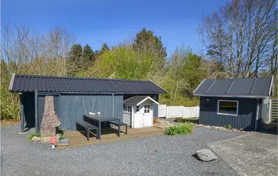 a smallshed with a picnic table and a bench at Three-Bedroom Holiday Home In Spottrup in Spottrup