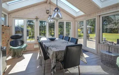 a conservatory dining room with a table and chairs at Three-Bedroom Holiday Home In Spottrup in Spottrup