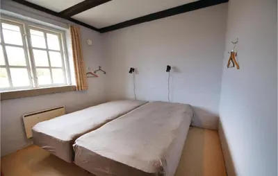 a bedroom with a large bed in a room with a window at Three-Bedroom Holiday Home In Spottrup in Spottrup