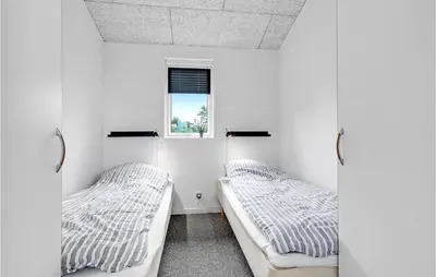 two beds in a white room with a window at Three-Bedroom Holiday Home In Skals in Skals