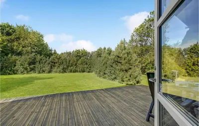 an open door to a deck with a view of a field at Two-Bedroom Holiday Home In Logstor in Løgstør