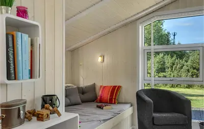 a room with a couch and a chair and a window at Two-Bedroom Holiday Home In Logstor in Løgstør
