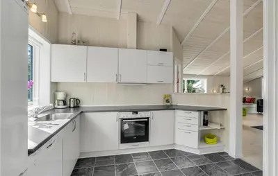 a kitchen with white cabinets and a counter top at Two-Bedroom Holiday Home In Logstor in Løgstør