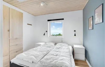 a white bedroom with a bed and a window at Three-Bedroom Holiday Home In Farso in Farsø