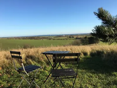 two chairs and a table in a field at Heltoften Bed & Breakfast in Nykøbing Mors