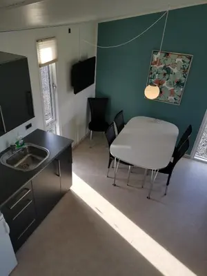 a kitchen with a table and a white table and chairs at Tangsø Hytteby in Bækmarksbro