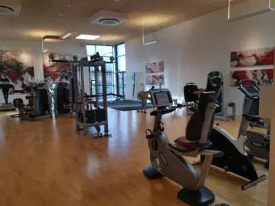a gym with several treadmills and exercise bikes at Tangsø Hytteby in Bækmarksbro