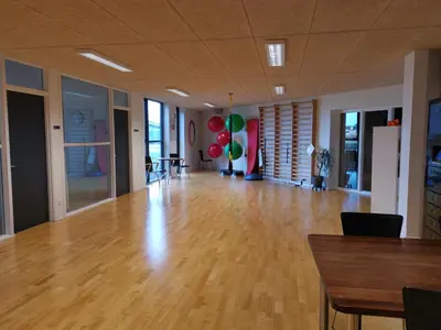 a large empty room with a wooden floor and balloons at Tangsø Hytteby in Bækmarksbro