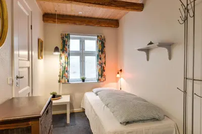 a bedroom with a bed and a desk and a window at Viborg City Rooms in Viborg