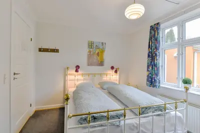 a bed in a white room with a window at Viborg City Rooms in Viborg