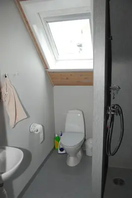 a bathroom with a toilet and a skylight at Viborg City Rooms in Viborg