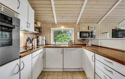a kitchen with white cabinets and a window at Three-Bedroom Holiday Home In Hurup Thy in Sindrup