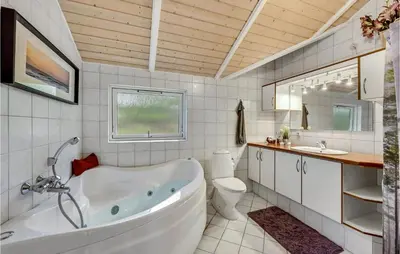 a bathroom with a tub and a toilet and a sink at Three-Bedroom Holiday Home In Hurup Thy in Sindrup