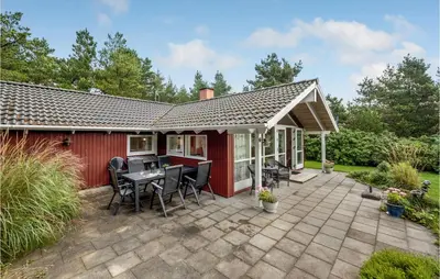 a house with a patio with a table and chairs at Three-Bedroom Holiday Home In Hurup Thy in Sindrup
