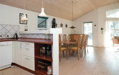 a kitchen and dining room with a table and chairs at Three-Bedroom Holiday Home In Blokhus in Blokhus