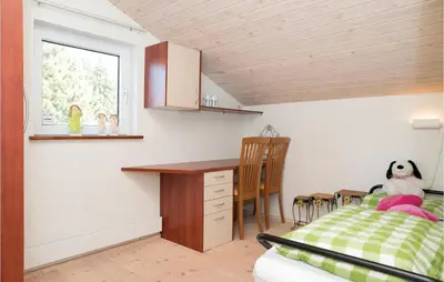 a bedroom with a desk and a bed and a table at Three-Bedroom Holiday Home In Blokhus in Blokhus