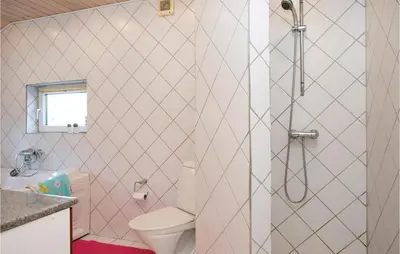 a white bathroom with a toilet and a shower at Three-Bedroom Holiday Home In Blokhus in Blokhus