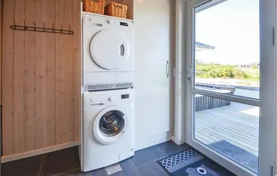 a laundry room with a washer and dryer next to a door at Four-Bedroom Holiday Home In Vestervig in Vestervig