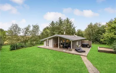 a small house with a deck in a yard at Four-Bedroom Holiday Home In Spottrup in Spottrup