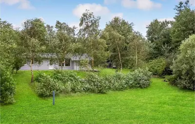 a house in the middle of a yard at Four-Bedroom Holiday Home In Spottrup in Spottrup