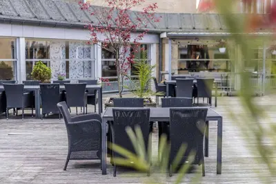 a group of tables and chairs in a patio at Comwell Rebild Bakker in Skorping