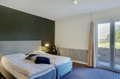 a bedroom with a bed and a large window at Montra Hotel Hanstholm in Hanstholm