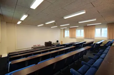 an empty lecture hall with blue chairs and a podium at Store Restrup Manor House in Store Restrup