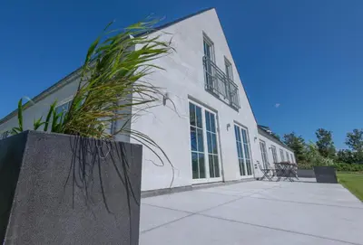 a white building with a plant in front of it at Kunstart20 in Saltum