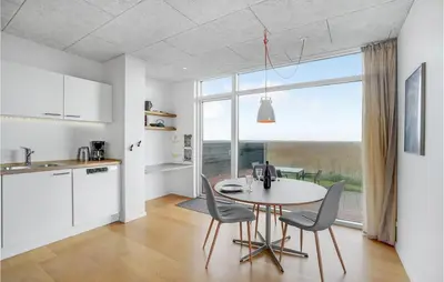 a kitchen and dining room with a table and chairs at One-Bedroom Holiday Home In Ulfborg in Ulfborg