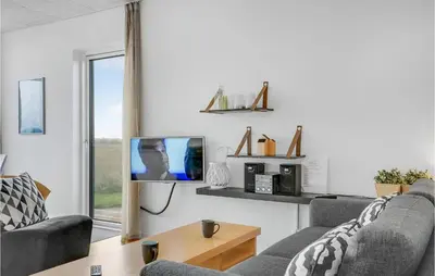 a living room with two couches and a tv at One-Bedroom Holiday Home In Ulfborg in Ulfborg