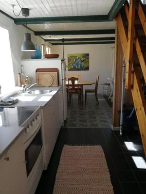 a kitchen with a sink and a table at Slettegaard in Slettestrand