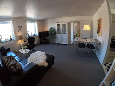 a living room with a couch and a table at Thy Ferielejlighed in Thisted