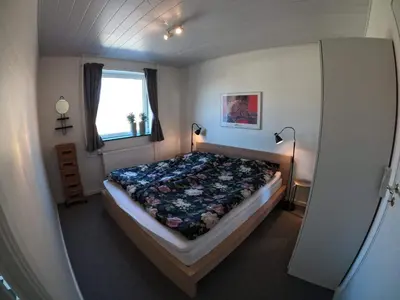 a bedroom with a bed in a room with a window at Thy Ferielejlighed in Thisted