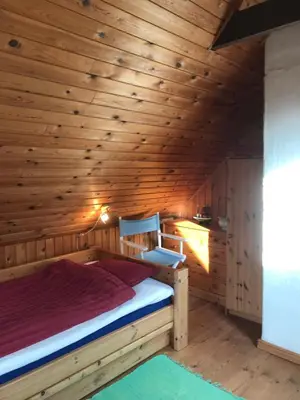 a bedroom with a bed in a wooden room at Country house in Karby