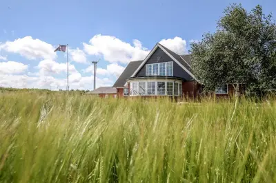 a house in the middle of a field of tall grass at Bed and Breakfast Lemvig in Lemvig