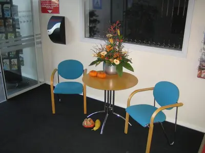a table with two chairs and a vase with flowers at Motel Skive in Skive