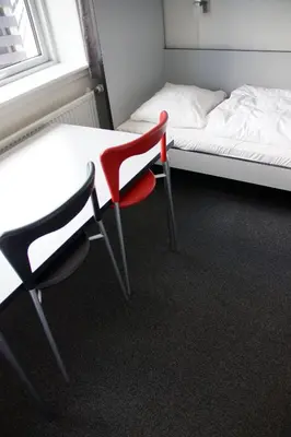 a room with a table and a chair next to a bed at Motel Skive in Skive