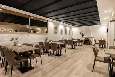 a restaurant with tables and chairs and a fireplace at Hotel Limfjorden in Thisted