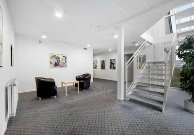 a hallway with chairs and stairs in a building at Hotel Søparken in Åbybro
