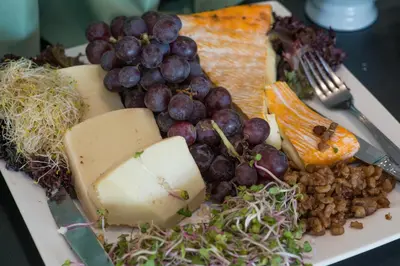 a plate of food with cheese grapes and other foods at Hotel Søparken in Åbybro