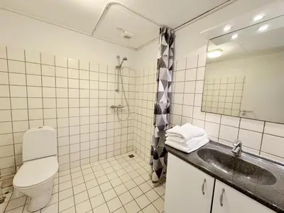 a bathroom with a toilet and a sink and a mirror at Hotel Søparken in Åbybro