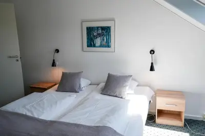 two beds in a room with white walls at Hotel Søparken in Åbybro