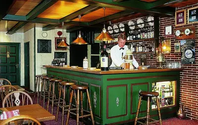 a man standing behind a bar in a restaurant at St. Binderup Kro in Store Binderup