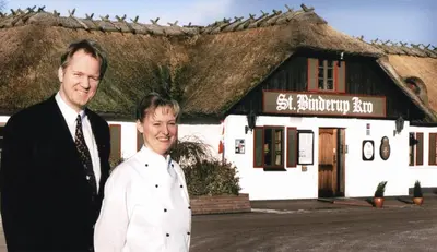 a man and a woman standing in front of a building at St. Binderup Kro in Store Binderup