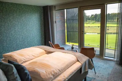 a bedroom with a bed and a large window at HimmerLand in Gatten